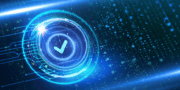 A digital blue check mark in a glowing circular interface, surrounded by light effects and abstract data particles on a dark background.