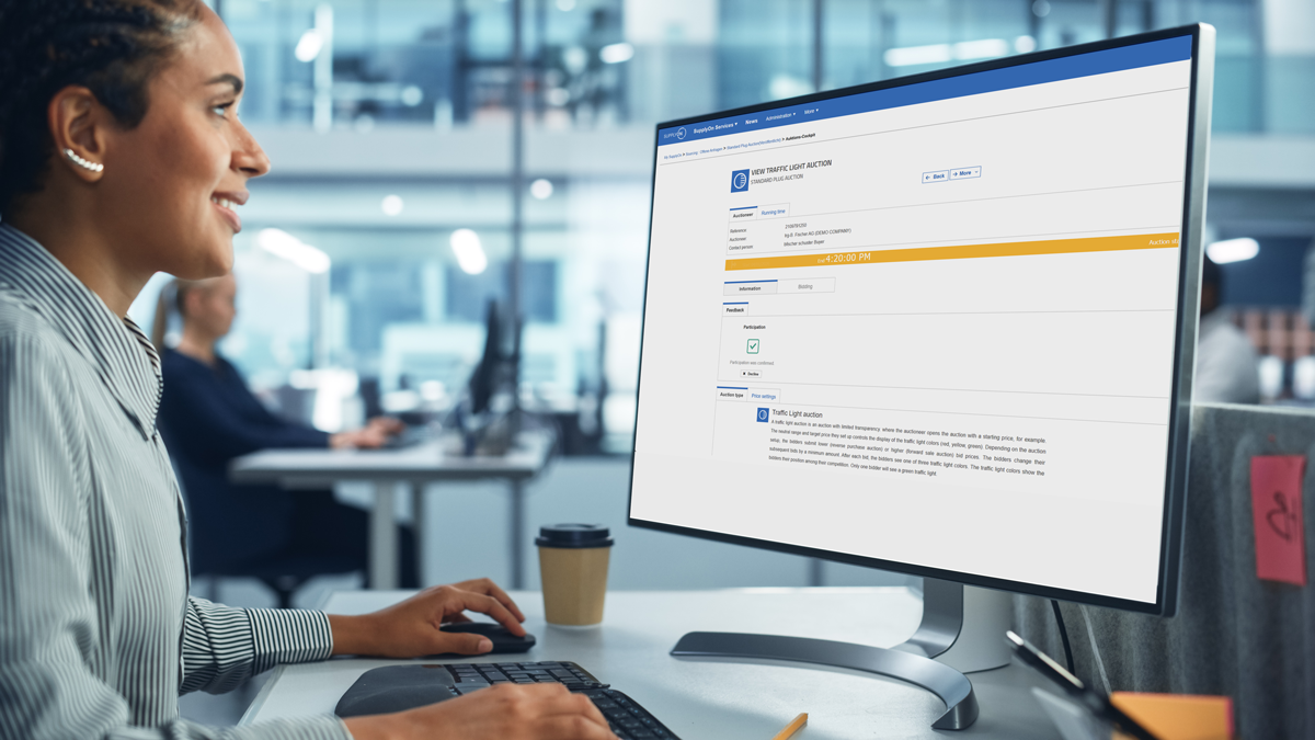 A person works at a desk, using a computer displaying a website with financial information and account details in an office setting.
