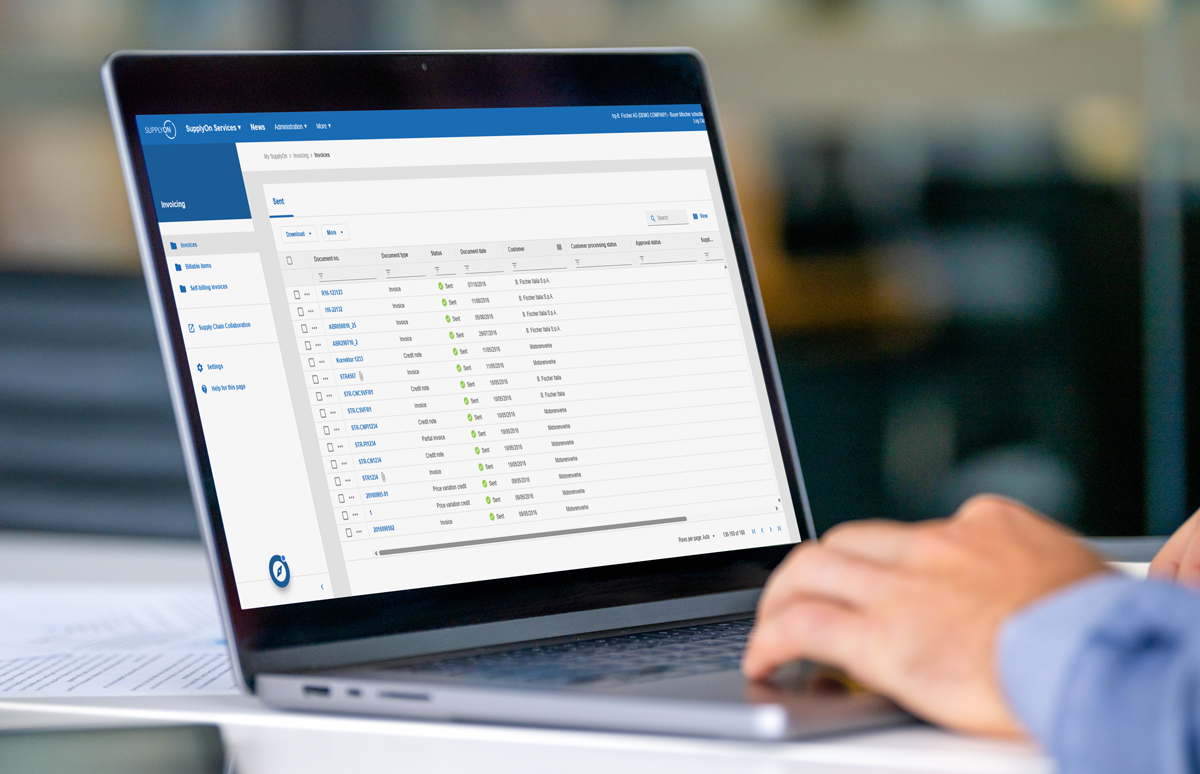 Person using a laptop displaying a business software dashboard with a list view of invoices, including columns for invoice numbers, due dates, amounts, and payment statuses.
