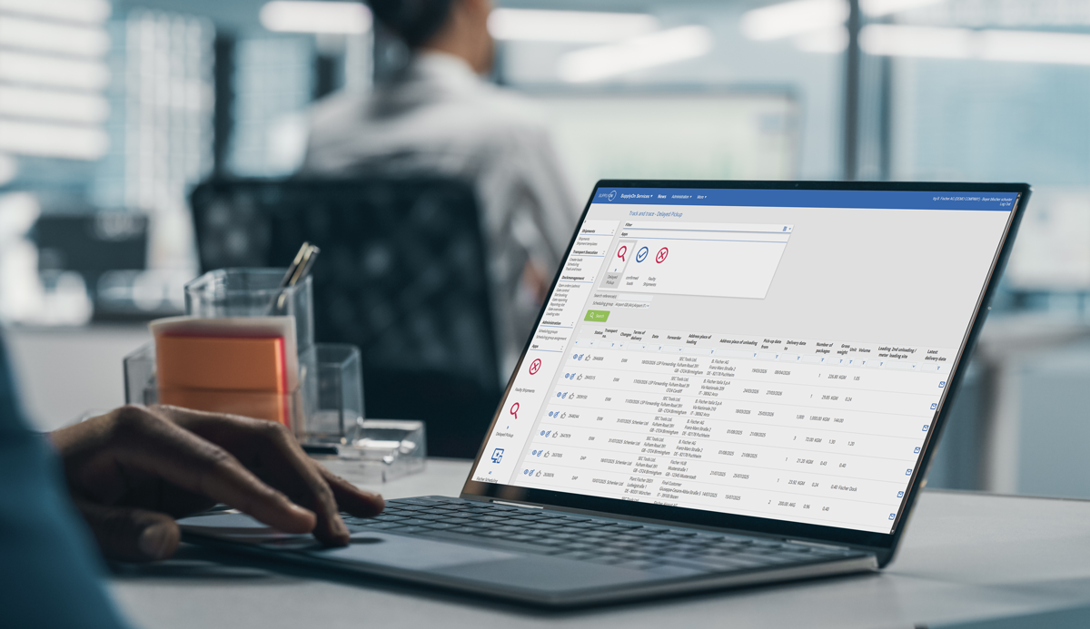 A person uses a laptop displaying a business dashboard with transaction data in a modern office setting.