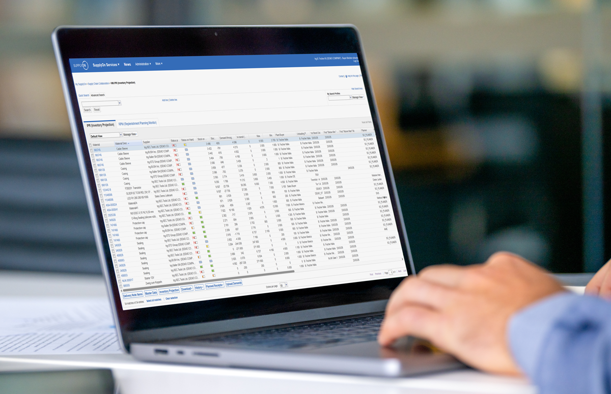 Person using a laptop displaying a detailed spreadsheet with rows and columns of financial or trading data in a software interface.